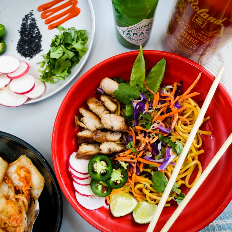 bowl of noodles with kimchi and other garnishes